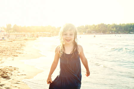 Cheerful child girl having fun on sea beachの写真素材