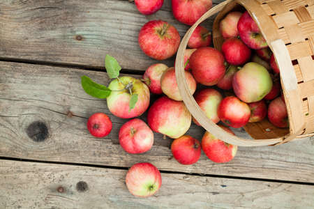 red Apples in basket on gray wooden backgroundの写真素材