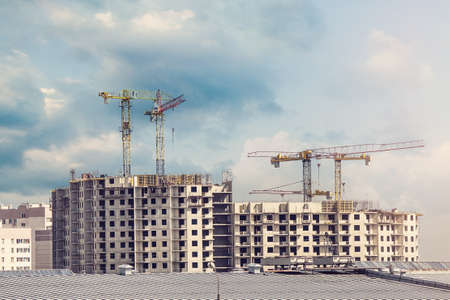 Crane and building under construction against blue sky