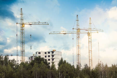 Crane and building under construction against blue sky