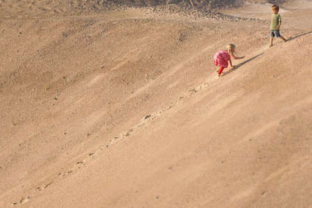 Children Climbing On The Sand dune. Summer dayの写真素材