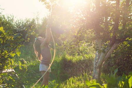 Adorable little girl playing with a garden hose. girl watering the tree.の写真素材