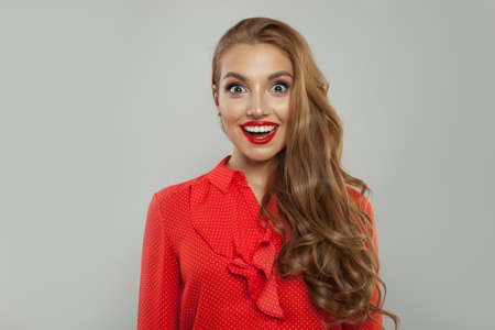 Excited model smiling on white background. Young surprised woman portraitの写真素材
