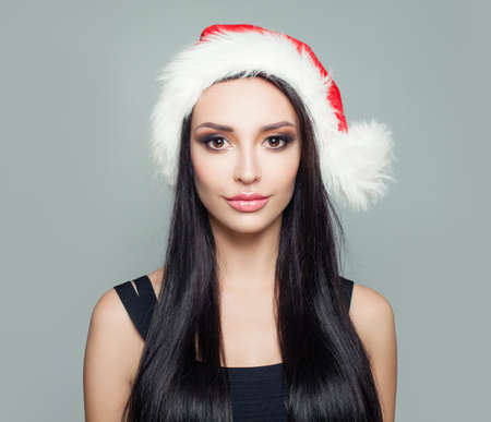 Beautiful woman brunette in Santa hat, Christmas portraitの写真素材
