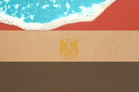 Sea wave on the sunny sandy beach with flag Egypt. View from top on surf.の写真素材