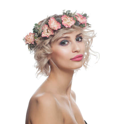 Beautiful blonde woman with short curly hair, makeup and flowers crown isolated on whiteの写真素材
