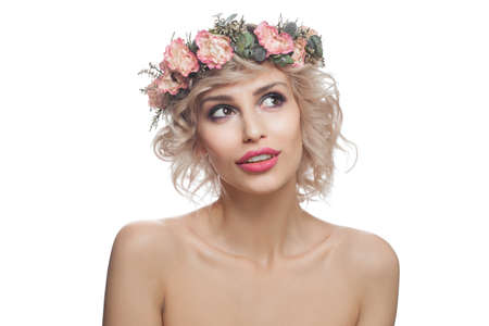 Isolated blonde woman with flowers crown on head. Pretty model with short curly haircutの写真素材
