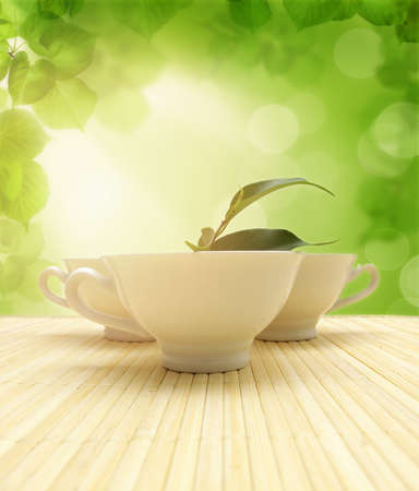 Three cups of tea and green leavesの写真素材