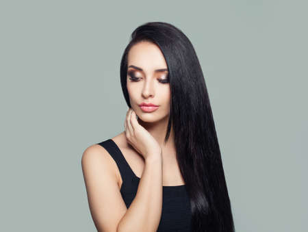 Young perfect woman with long dark straight hair and makeup portraitの写真素材
