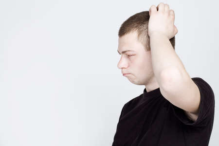 Confused Man Scratching Head. A confused young man is scratching his headの写真素材