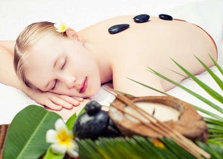 Spa massage. Beautiful young woman getting spa massage. Focus on peopleの写真素材