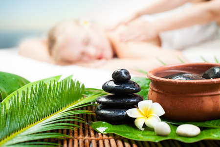 Spa massage outdoor. Beautiful young woman getting spa massage. Focus on Spa objectの写真素材