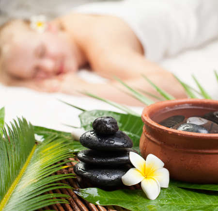 Spa massage. Beautiful young woman getting spa massage. Focus on Spa objectsの写真素材