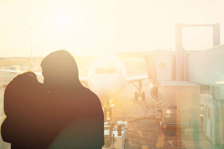 Couple kiss near window in airport. The concept of meeting or parting two peopleの写真素材