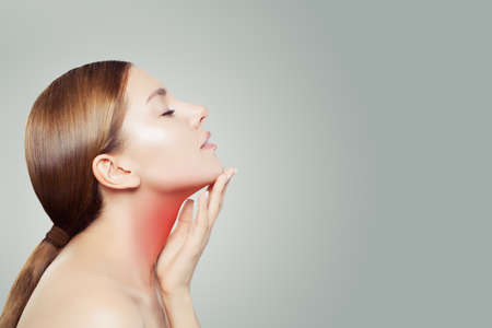 Young Woman with a Sore Throat. Woman Puts Hands on the Neckの写真素材