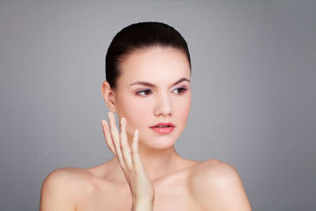 Cute model woman with clear skin on gray backgroundの写真素材