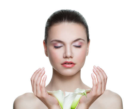 Spa model woman with clear skin and flowers in hands isolated on white. Spa beauty portraitの写真素材