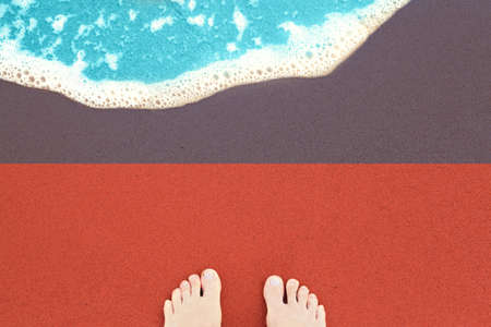 Feet on the sunny sandy beach with flag Haiti. View from top on surf.の写真素材