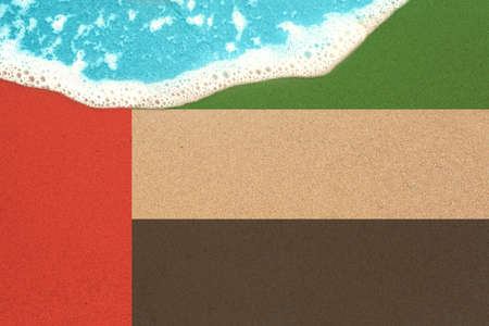 Background the sunny sandy beach with flag AUE. Top View on sea surf.の写真素材