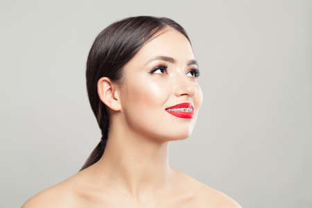 Cute woman in braces smiling on whiteの写真素材