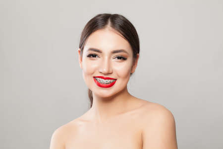 Happy girl in braces smiling on whiteの写真素材