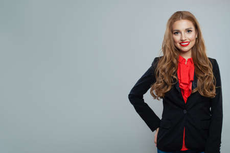 Happy woman student on gray background. Business woman in black suit portraitの写真素材