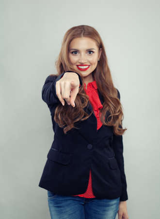 Pointing hand of happy woman on gray backgroundの写真素材