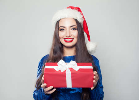 Happy woman in braces and Christmas gift on whiteの写真素材
