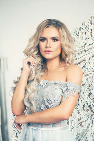 Beautiful woman dreaming in white vintage interiorの写真素材