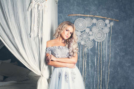 Beautiful model woman in gray tulle dress relaxing in vintage interiorの写真素材