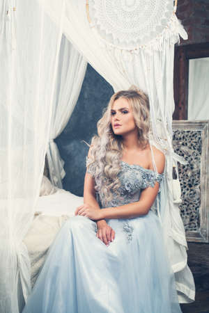 Beautiful model girl in tulle dress relaxing in vintage interiorの写真素材