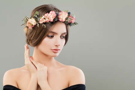 Pretty young woman wearing flowers wreath on gray bannerの写真素材