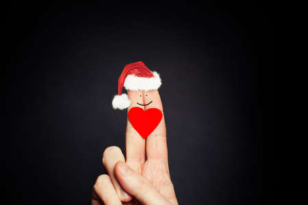 Christmas Holiday Concept. Happy fingers Face in Santa Hats. Couple relationshipsの写真素材