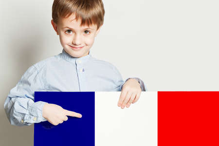 Happy child boy holding the Franch flag banner on white empty backgroundの写真素材