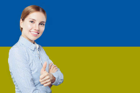 Portrait of cute smiling woman with Ukrainian flag. Business and travel conceptの写真素材