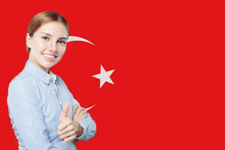 Portrait of happy woman with thumb up on Turkish flagの写真素材