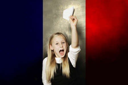 Happy kid with plane against France flag background. Learning French conceptの写真素材