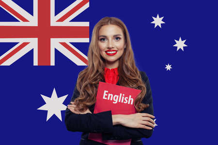 Happy smiling woman student with book against Australian flagの写真素材