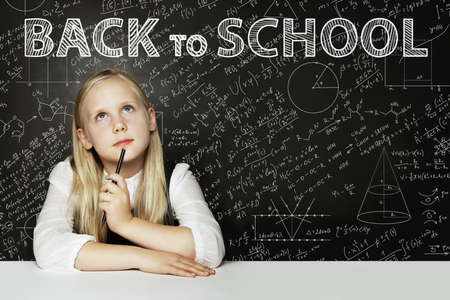 Smiling Student girl dreaming on chalkboard. Back to school backgroundの写真素材