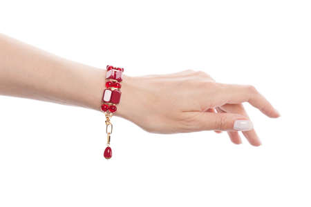 Bracelet with red coral on female hand isolated on white backgroundの写真素材