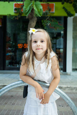 Little Girl in white dress playing in the cityの写真素材
