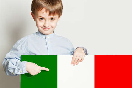 Happy child boy holding the Italian flag on white backgroundの写真素材