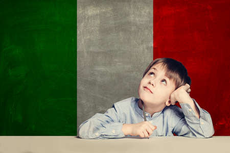 Thinking child boy student against the Italy flag background. Italian conceptの写真素材
