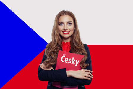 Smiling woman portrait against the Czech Republic flag. Travel and learn czech language. Book with inscription Czech on Czech languageの写真素材