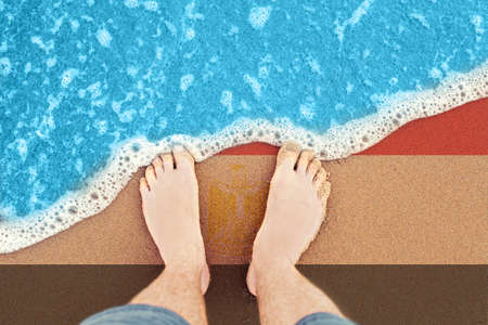 Feet on the sunny sandy beach with flag Egypt. Top vew on sea wave.の写真素材