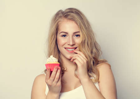 Smiling Cute Girl holding Cake in her hands. Woman with Beautiful Toothy Smileの写真素材