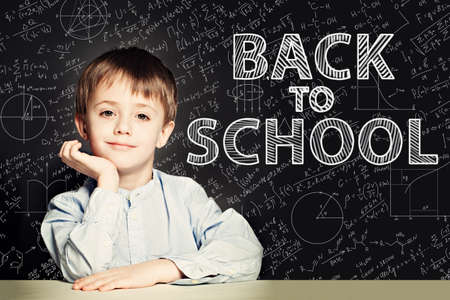 Smiling Student child thinking on chalkboard. Back to school conceptの写真素材