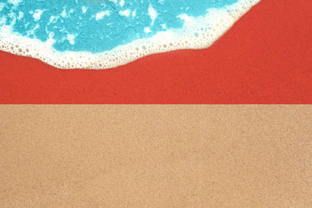 Sea wave on the sunny sandy beach with flag Indonesia. View from top on surf.の写真素材