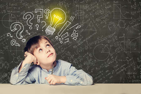 Idea! Smart kid student with lightbulb on blackboardの写真素材