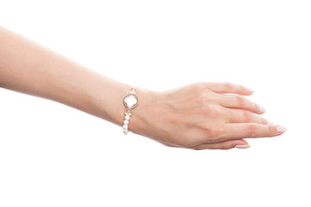 Beautiful woman hand wearing jewelry bracelet with nacre and pearls isolated on white backgroundの写真素材